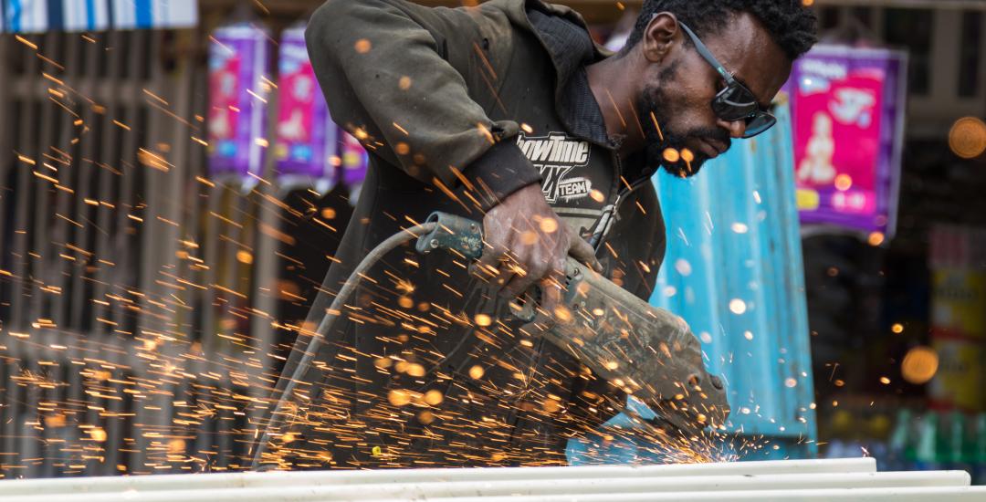 Young man grinding metal